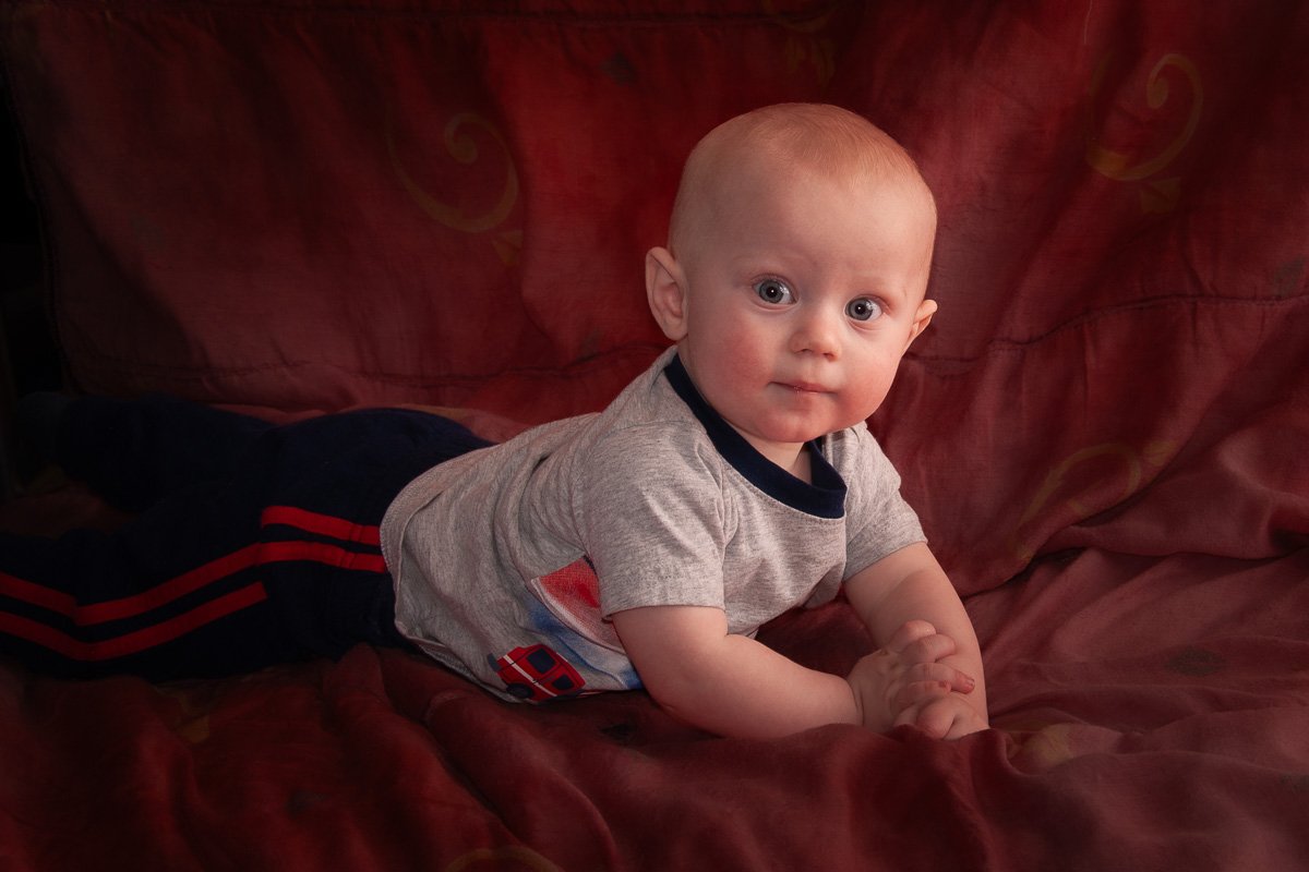 Young boy with expressive eyes looking up at the camera during a candid photography session.